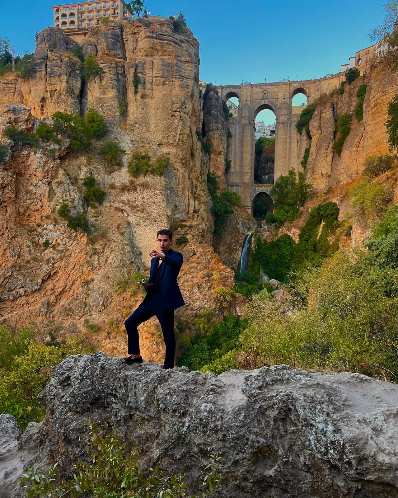 Course founder in a navy suit standing on rocks in front of the Ronda gorge